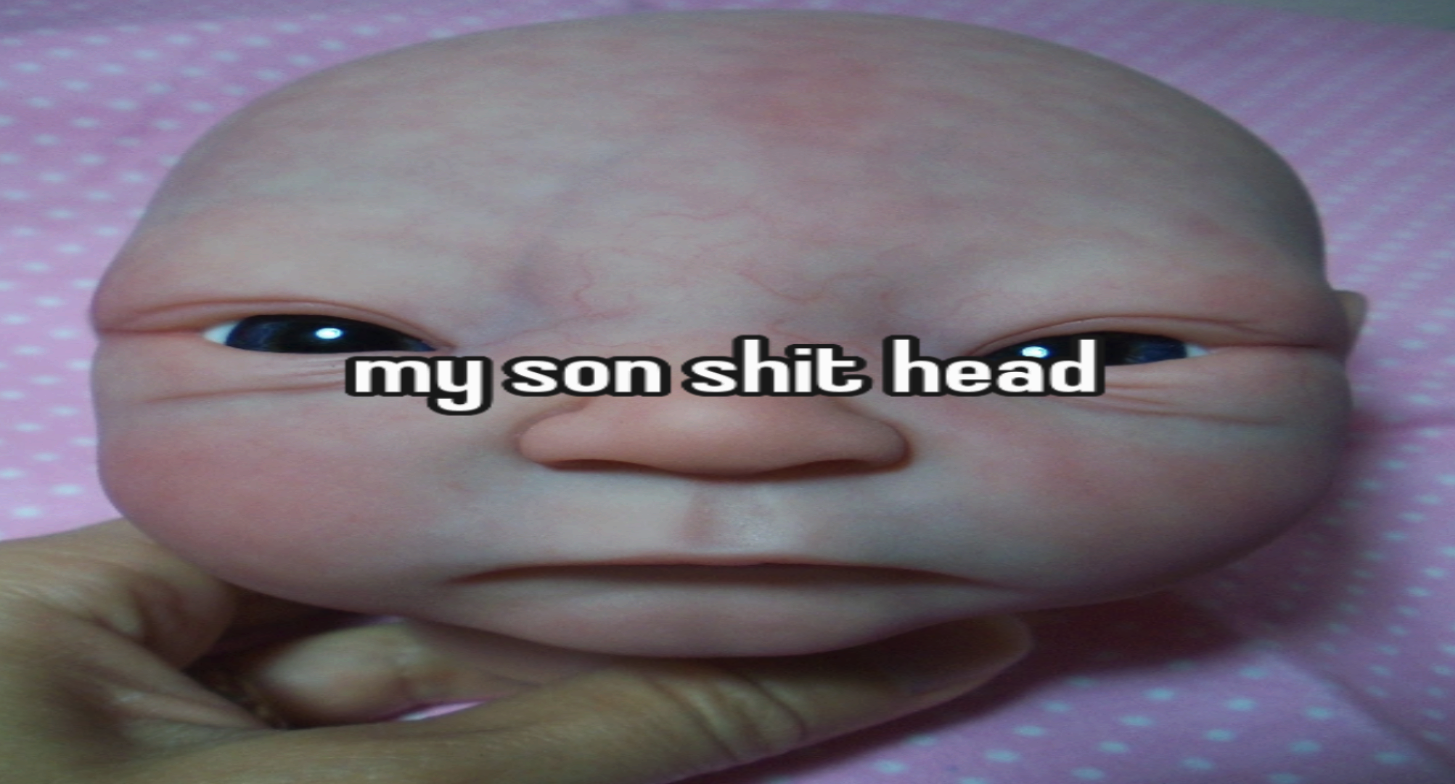 A reborn baby doll head captioned: my son shit head